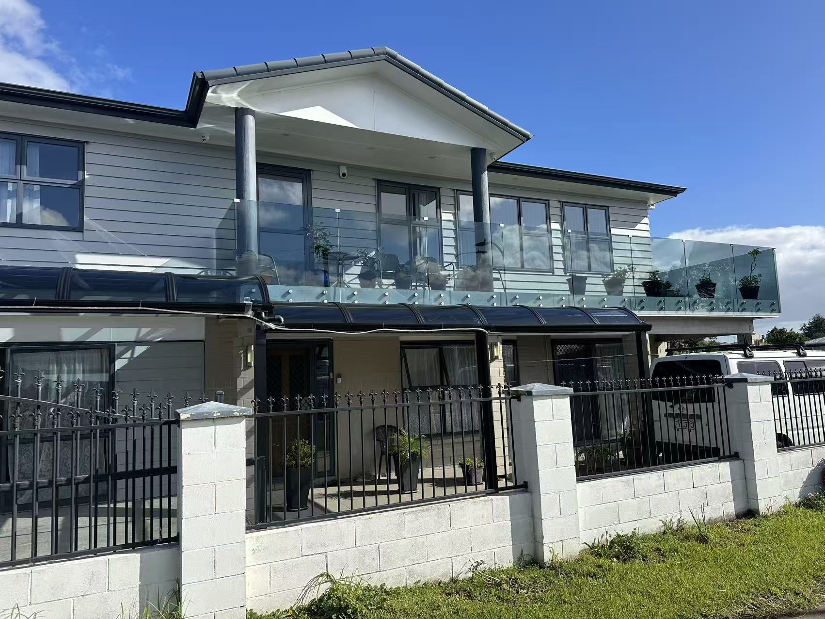 Two storey home with curved glass canopies and glass balustrade