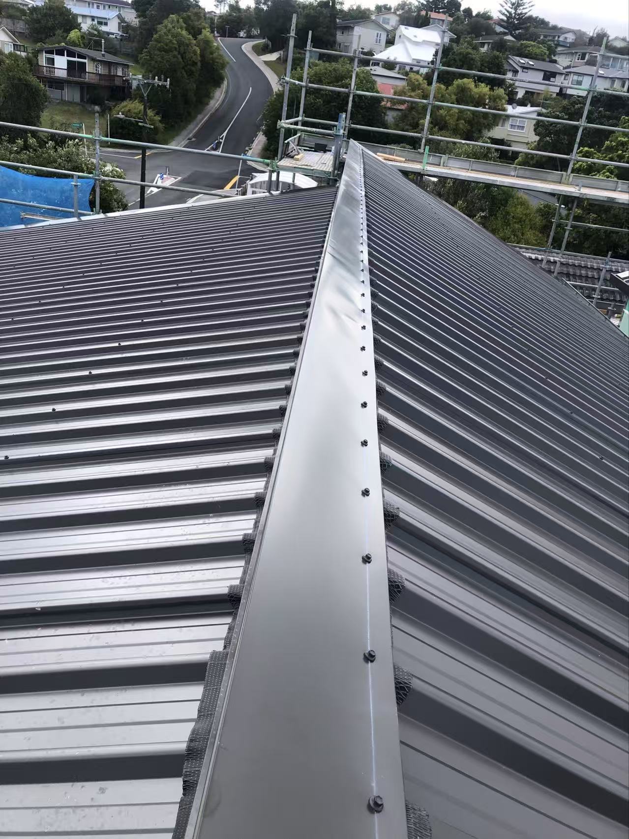 New longrun metal roof installation with finished ridge flashing in Auckland