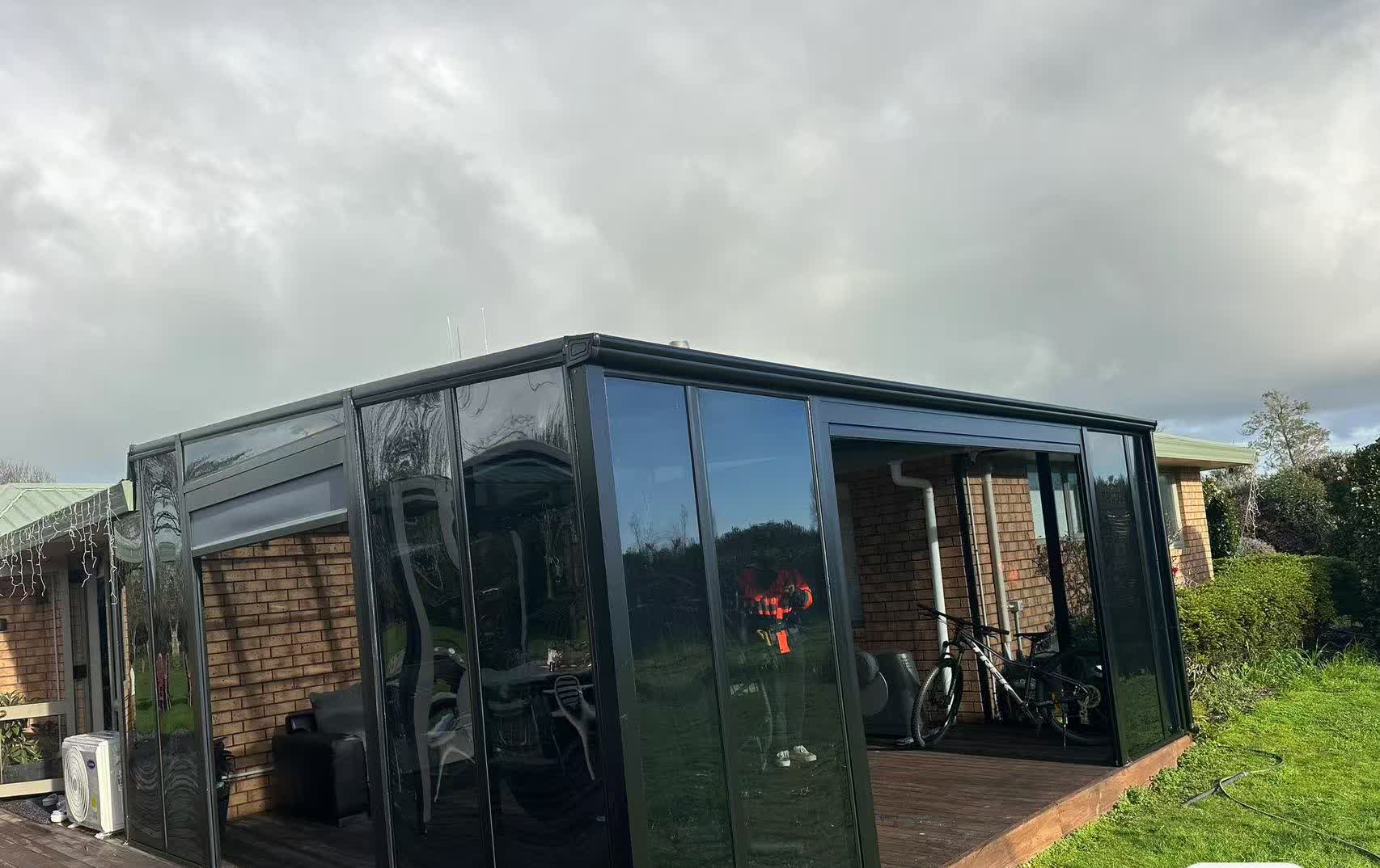 Black aluminium glass sunroom on a lawn